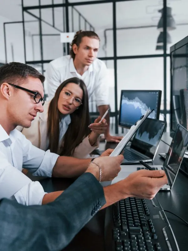 Team reviewing information across several screens
