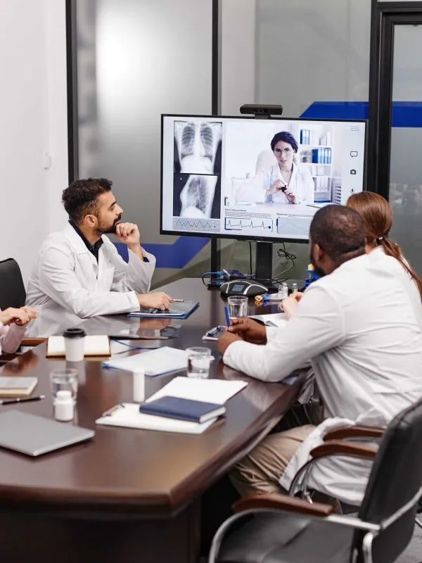 Group of clinicians listening to a colleague in a meeting room